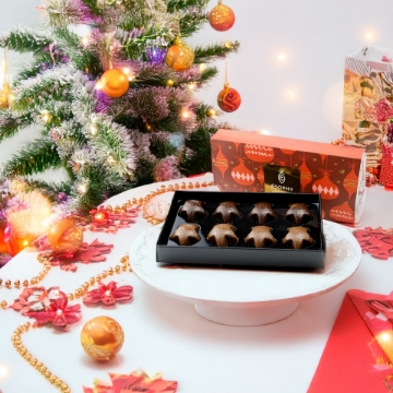 Premium Corporate Food Gifts – Mediterranean Pralines for Holiday & Corporate Gifting. Gourmet Chocolate Gift Set in festive packaging under a Christmas tree, featuring ÉSOPHY Luxury Greek Pralines.
