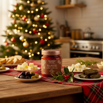 Navarino Icons Stuffed Peppers for a Festive Greek Meze Platter A festive Greek meze table with Navarino Icons stuffed red peppers, dolmades, olives, and feta, set in front of a Christmas tree.