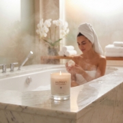 Aurean scented candle in luxury spa bathroom with woman relaxing, premium wellness and relaxation ambiance